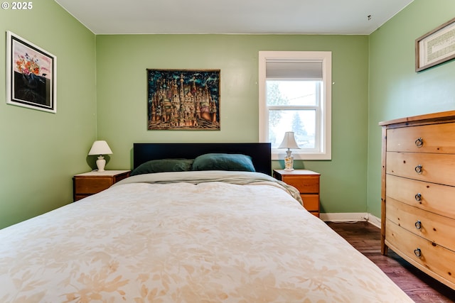 bedroom featuring baseboards and dark wood-type flooring
