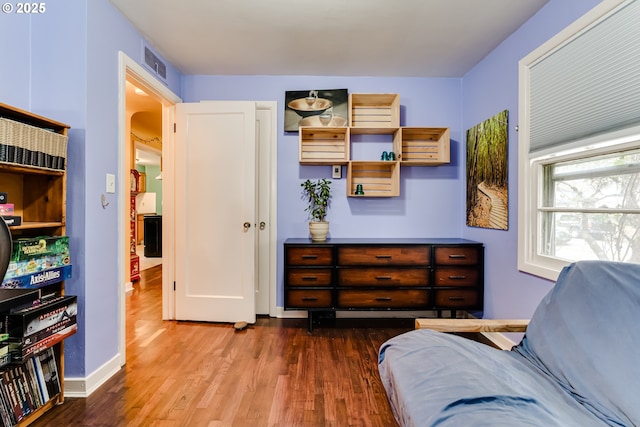 sitting room featuring visible vents, arched walkways, baseboards, and wood finished floors
