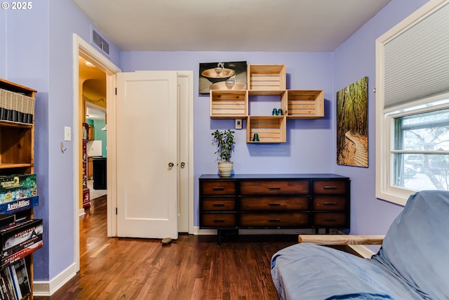 living area with visible vents, arched walkways, baseboards, and wood finished floors