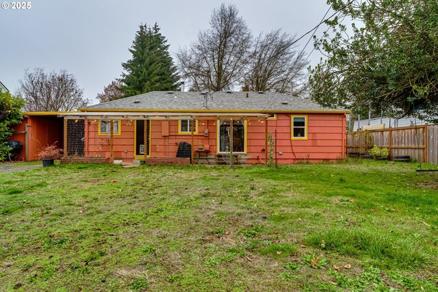 back of property with fence and a lawn