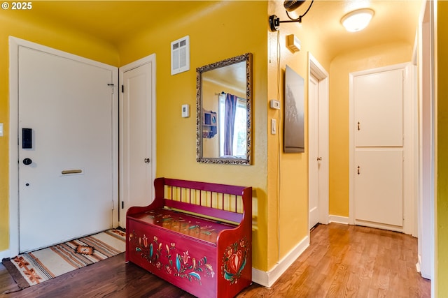 entryway featuring baseboards, wood finished floors, and visible vents