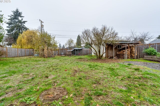 view of yard with an outbuilding, a fenced backyard, and a shed