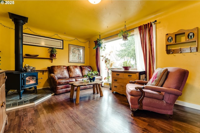 sitting room with baseboards, a wood stove, and dark wood-type flooring