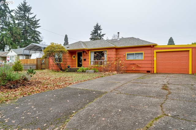 view of front of home featuring an attached garage, fence, and driveway