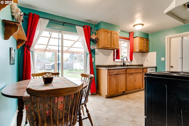 kitchen featuring plenty of natural light, a sink, black range with electric cooktop, and dark countertops