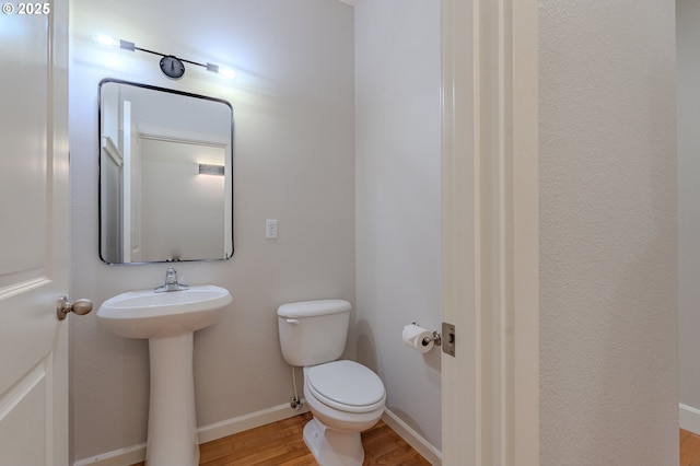 bathroom featuring hardwood / wood-style flooring and toilet