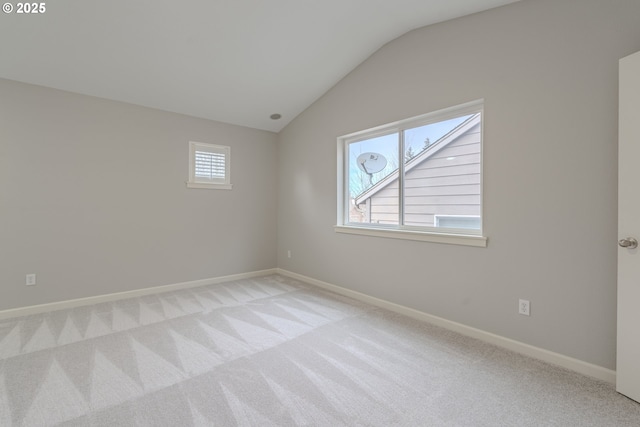 unfurnished room with lofted ceiling and light colored carpet