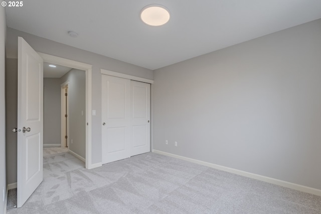 unfurnished bedroom featuring light carpet and a closet