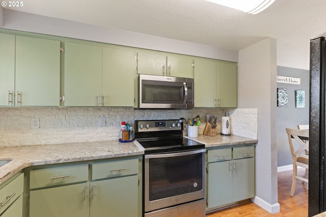 1448 S Grove Lane Ct, Sutherlin, OR 97479 - kitchen with appliances with stainless steel finishes, light wood-style flooring, backsplash, light countertops, and baseboards