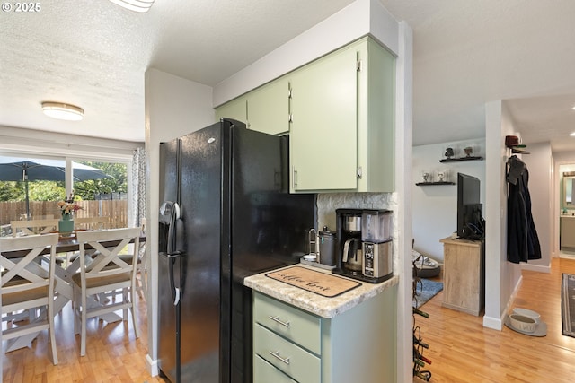 1448 S Grove Lane Ct, Sutherlin, OR 97479 - kitchen featuring green cabinets, black refrigerator with ice dispenser, light wood finished floors, light countertops, and a textured ceiling