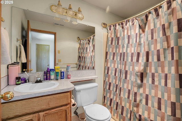 bathroom featuring toilet, vanity, and curtained shower