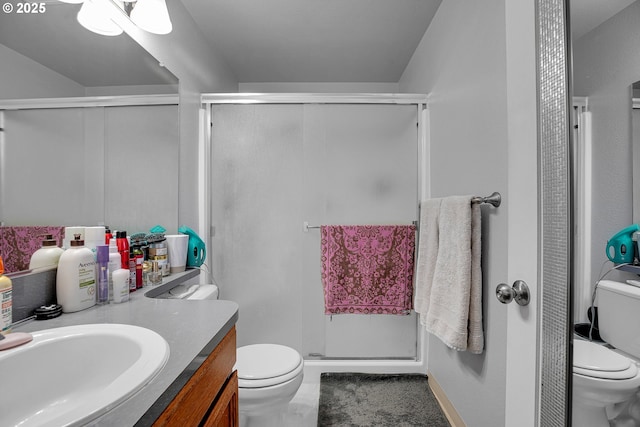 full bath featuring toilet, vanity, and a stall shower
