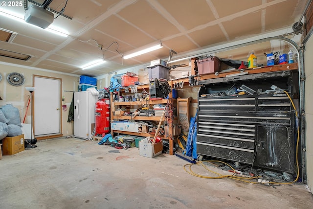 garage with a garage door opener and a workshop area