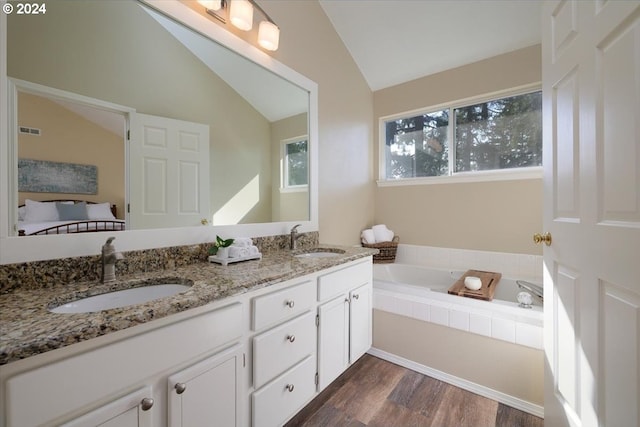 4506 Black Forest Ct, Lake Oswego, OR 97035 - ensuite bathroom featuring lofted ceiling, a garden tub, double vanity, and wood finished floors