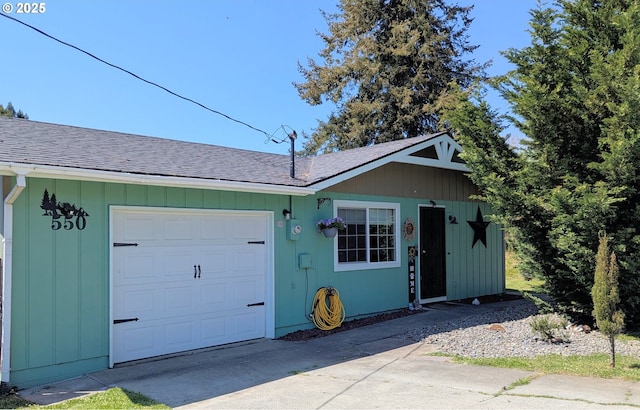 exterior space featuring a garage, roof with shingles, and driveway