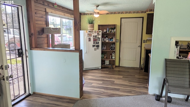 kitchen featuring a textured ceiling, freestanding refrigerator, a ceiling fan, and wood finished floors