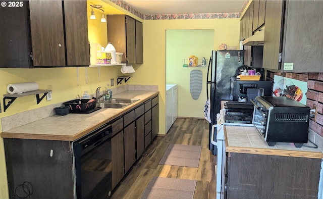 kitchen featuring tile countertops, dishwasher, a sink, dark wood-style floors, and under cabinet range hood