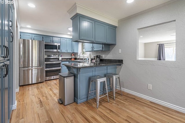 1216 Montgomery Pl NE, Albany, OR 97321 - kitchen with stainless steel appliances, a peninsula, a sink, a textured wall, and ornamental molding