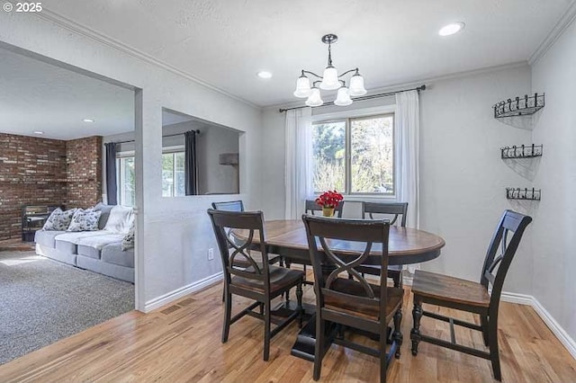 1216 Montgomery Pl NE, Albany, OR 97321 - dining room featuring plenty of natural light, light wood-style floors, a chandelier, crown molding, and baseboards