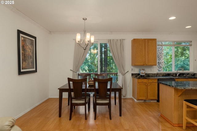 dining space featuring baseboards, light wood-style floors, a chandelier, and crown molding