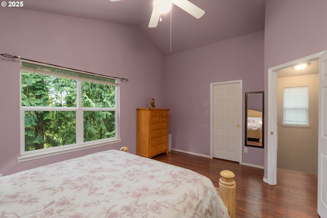 bedroom featuring baseboards, dark wood-type flooring, a ceiling fan, and vaulted ceiling