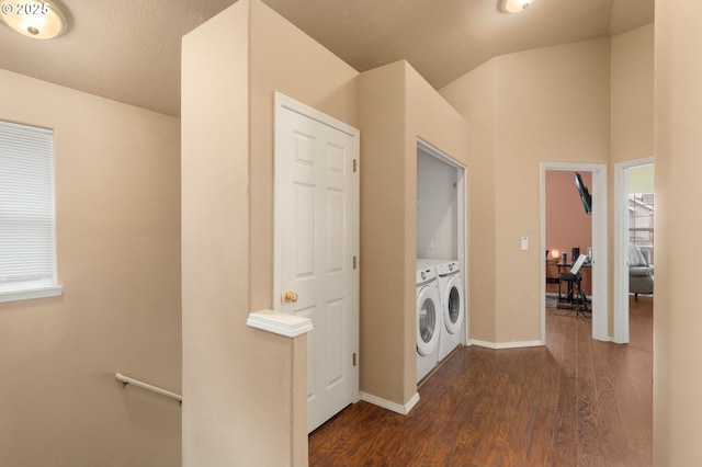 clothes washing area with washer and dryer, laundry area, baseboards, and dark wood-type flooring