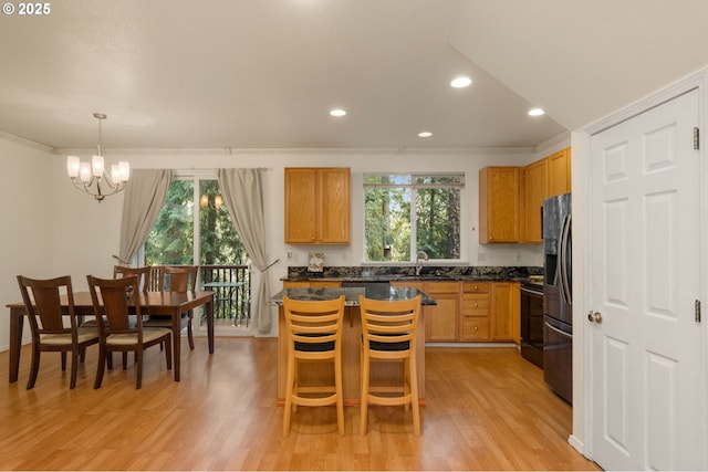 kitchen with plenty of natural light, light wood finished floors, and a sink