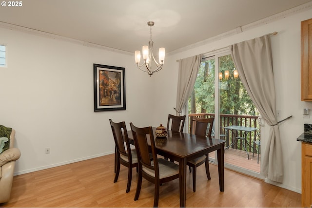 dining space with baseboards, a chandelier, ornamental molding, and light wood finished floors