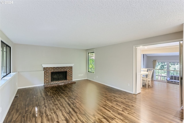 unfurnished living room with wood-type flooring, a textured ceiling, and a fireplace