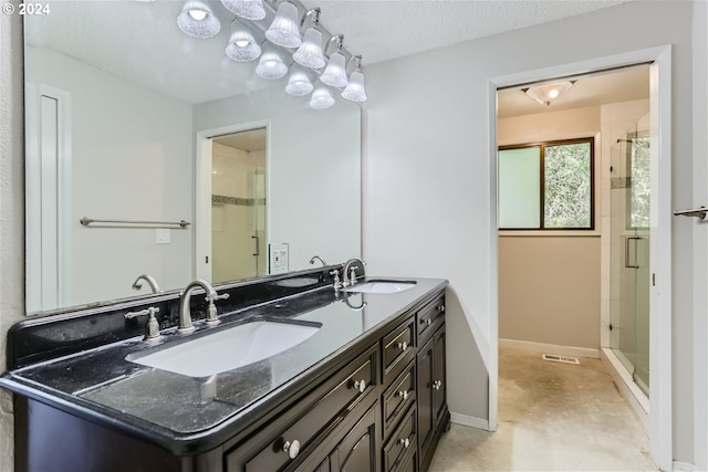 bathroom featuring vanity, a shower with door, and a textured ceiling