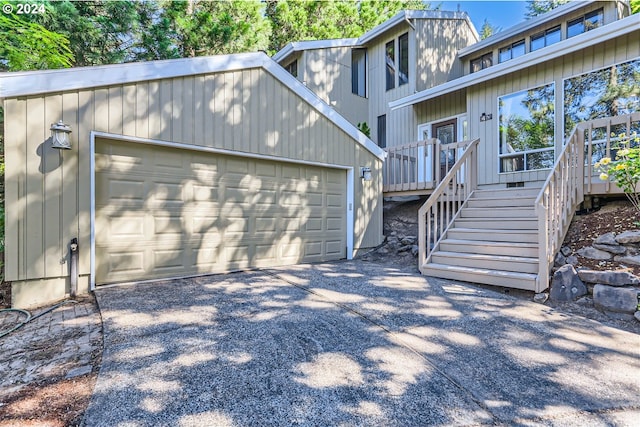 rear view of property featuring a garage and a deck