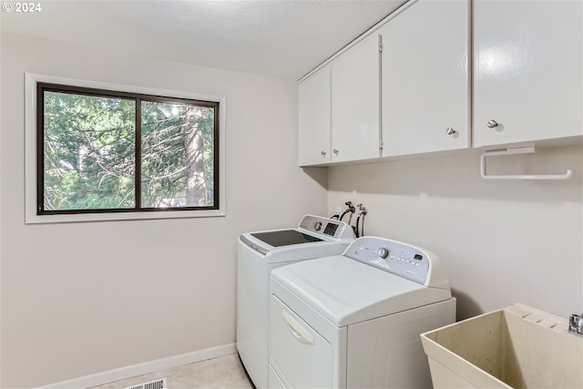 laundry area featuring cabinets, sink, light tile patterned floors, and independent washer and dryer