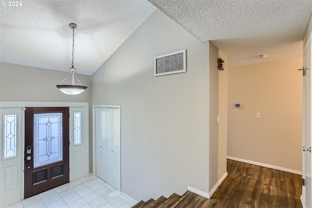 entrance foyer with hardwood / wood-style floors and a textured ceiling