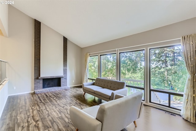 living room featuring hardwood / wood-style floors, a fireplace, and high vaulted ceiling