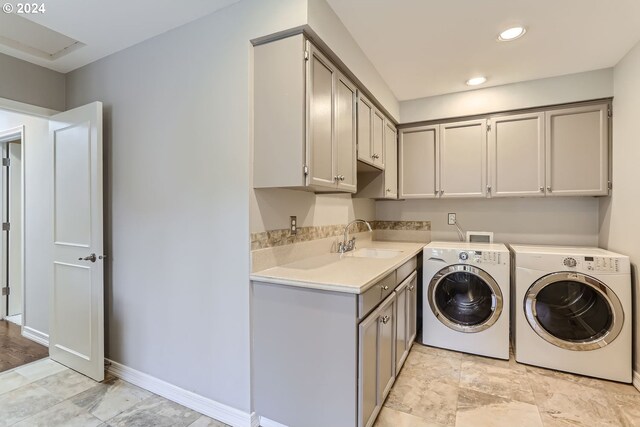 washroom with cabinets, sink, and washer and clothes dryer