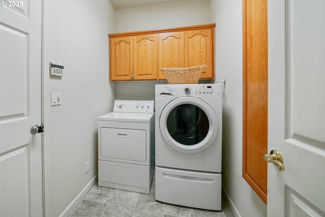 laundry room featuring cabinets and washing machine and clothes dryer