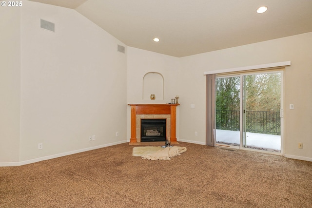 unfurnished living room with carpet flooring, vaulted ceiling, and a tile fireplace