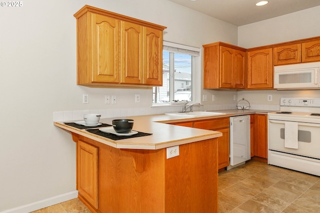 kitchen featuring white appliances, sink, and kitchen peninsula