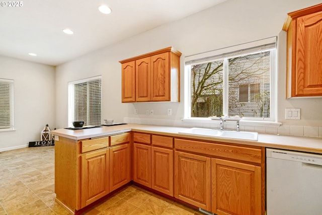 kitchen featuring sink, kitchen peninsula, and dishwasher