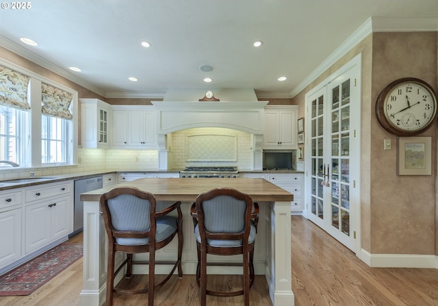 2943 Riverwalk Loop, Eugene, OR 97401 - kitchen with stainless steel dishwasher, a sink, butcher block countertops, french doors, and white cabinetry