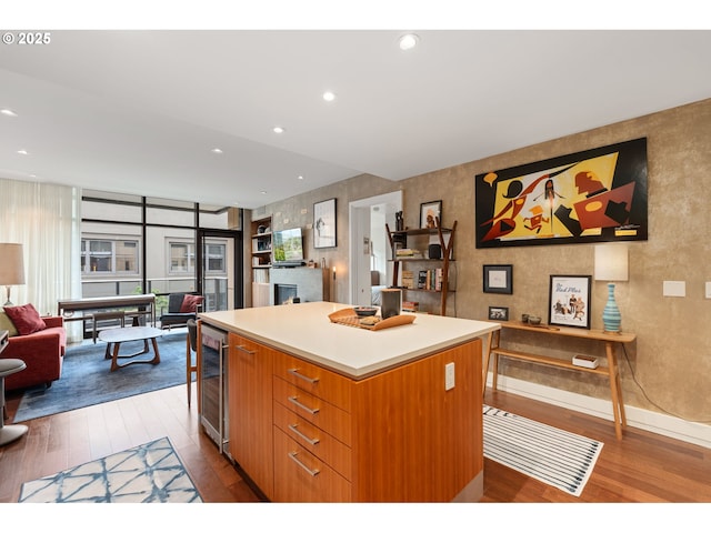 kitchen with dark wood-style flooring, beverage cooler, open floor plan, a center island, and light countertops