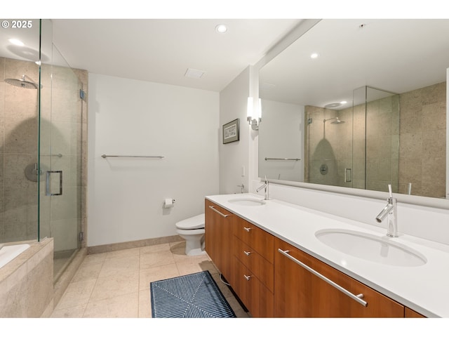 bathroom with a sink, baseboards, a shower stall, and toilet
