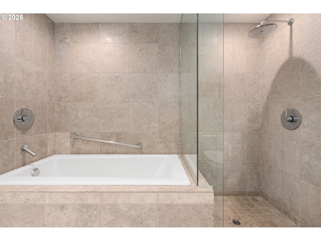 full bathroom featuring tiled bath and a tile shower