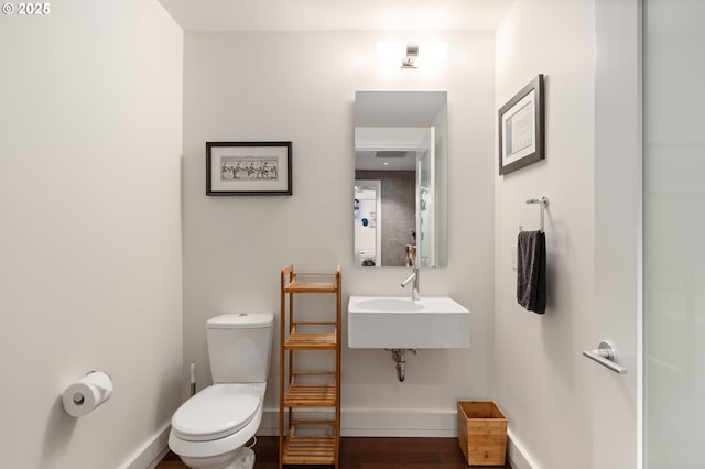 311 NW 12th Ave Unit 603, Portland, OR 97209 - half bath featuring toilet, baseboards, and wood finished floors