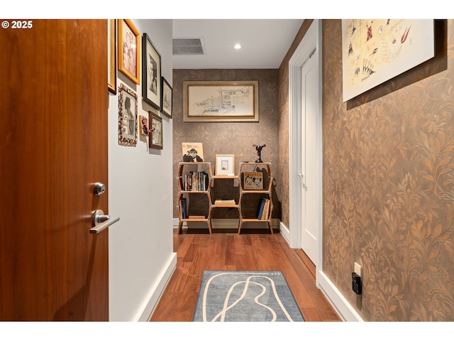interior space with baseboards, recessed lighting, wood finished floors, and visible vents