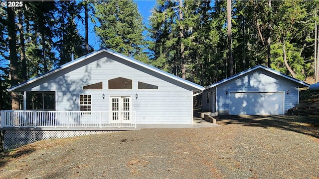 unfurnished living room featuring a wood stove, hardwood / wood-style floors, high vaulted ceiling, and french doors