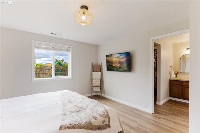 bedroom with baseboards, visible vents, and light wood-style flooring