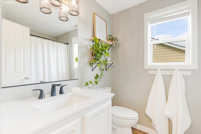bathroom with vanity, toilet, a chandelier, baseboards, and a shower with curtain