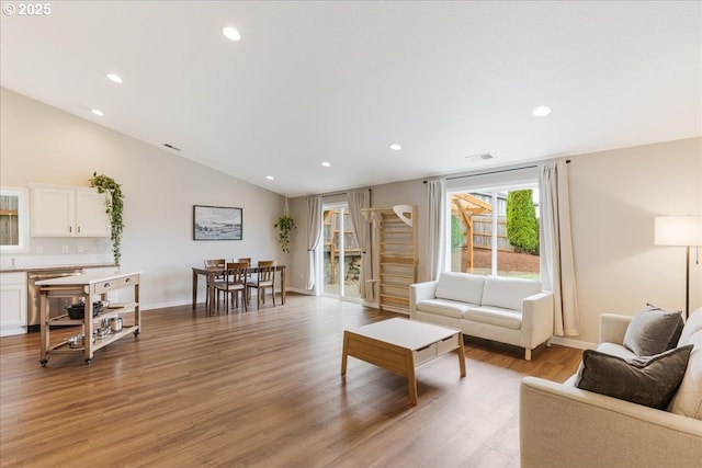 living room with light wood-style floors, recessed lighting, baseboards, and vaulted ceiling