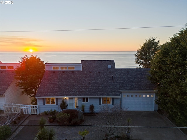 view of front of property with a garage and a water view